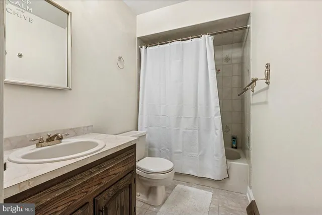 a bathroom with a granite countertop sink toilet a mirror and shower