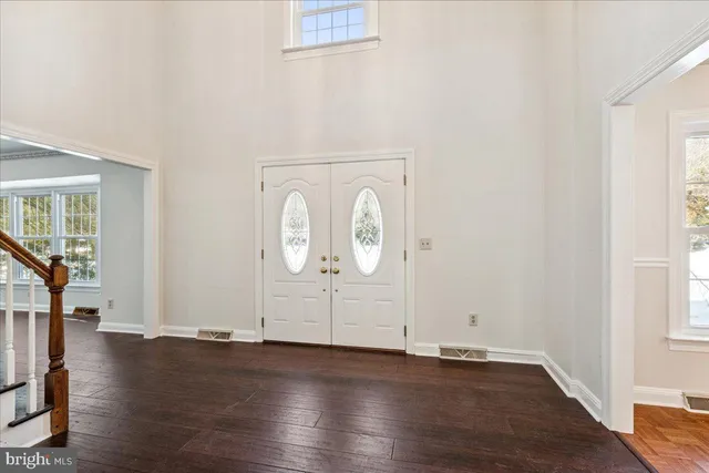 an empty room with wooden floor and window