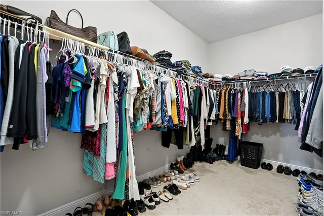 a view of walk in closet with clothes