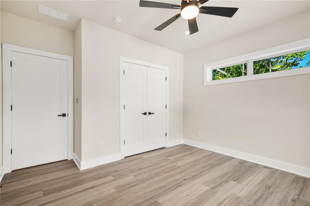 237 Altoona Place Southwest Atlanta, GA 30314 - Photo 46 of 63 an empty room with wooden floor ceiling fan and windows