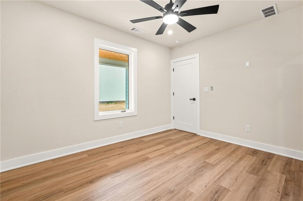 237 Altoona Place Southwest Atlanta, GA 30314 - Photo 51 of 63 an empty room with wooden floor fan and windows