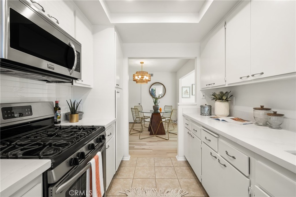 126 Clearbrook Irvine, CA 92614 - Photo 13 of 44 a kitchen with stainless steel appliances a stove a sink and a microwave