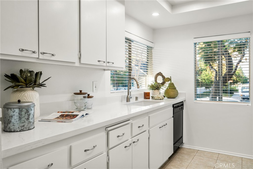 126 Clearbrook Irvine, CA 92614 - Photo 10 of 44 a kitchen with stainless steel appliances white cabinets and a window