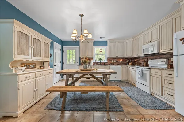 a kitchen with a dining table chairs sink and cabinets