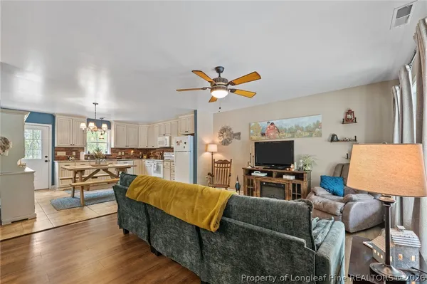 a living room with furniture flat screen tv and a large window