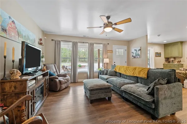 a living room with furniture kitchen view and a large window