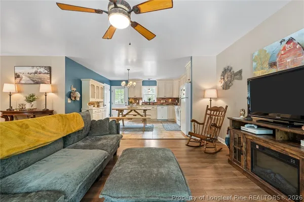 a kitchen with stainless steel appliances granite countertop a stove top oven a sink dishwasher a dining table and chairs with white cabinets