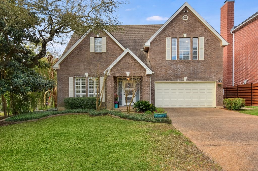 a front view of a house with a yard and garage