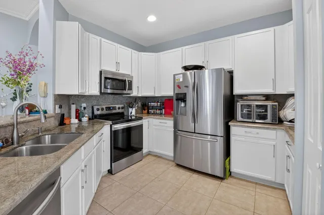 a kitchen with granite countertop a refrigerator stove and microwave