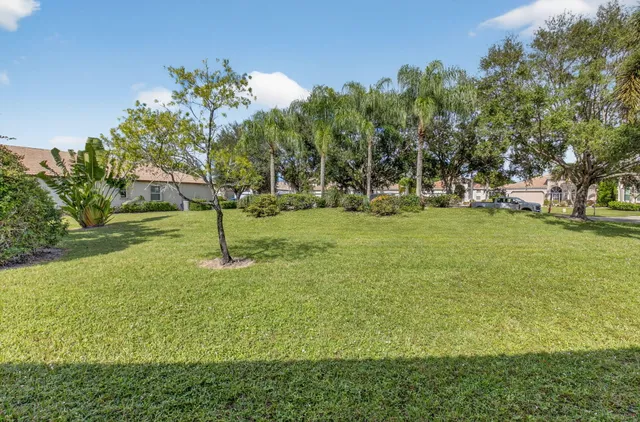 a front view of a house with a yard and potted plants