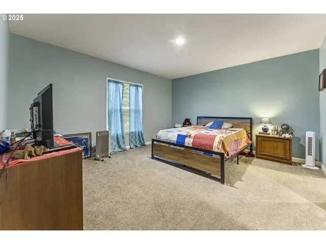 a bedroom with a bed and a view of kitchen
