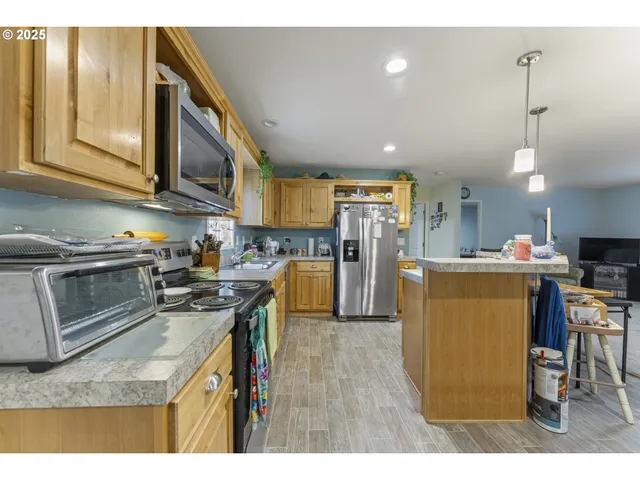 a kitchen with a sink a stove a refrigerator cabinets and a dining room