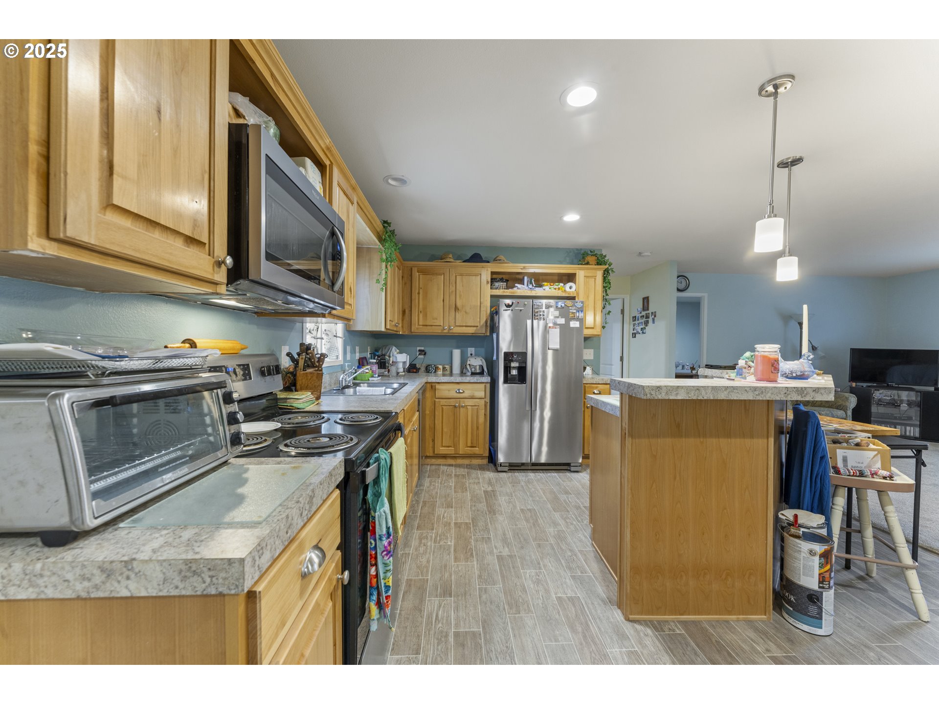 69127 Wildwood Road, Unit 4 North Bend, OR 97459 - Photo 9 of 20 a kitchen with stainless steel appliances granite countertop a refrigerator a stove top oven a sink dishwasher and white cabinets with wooden floor