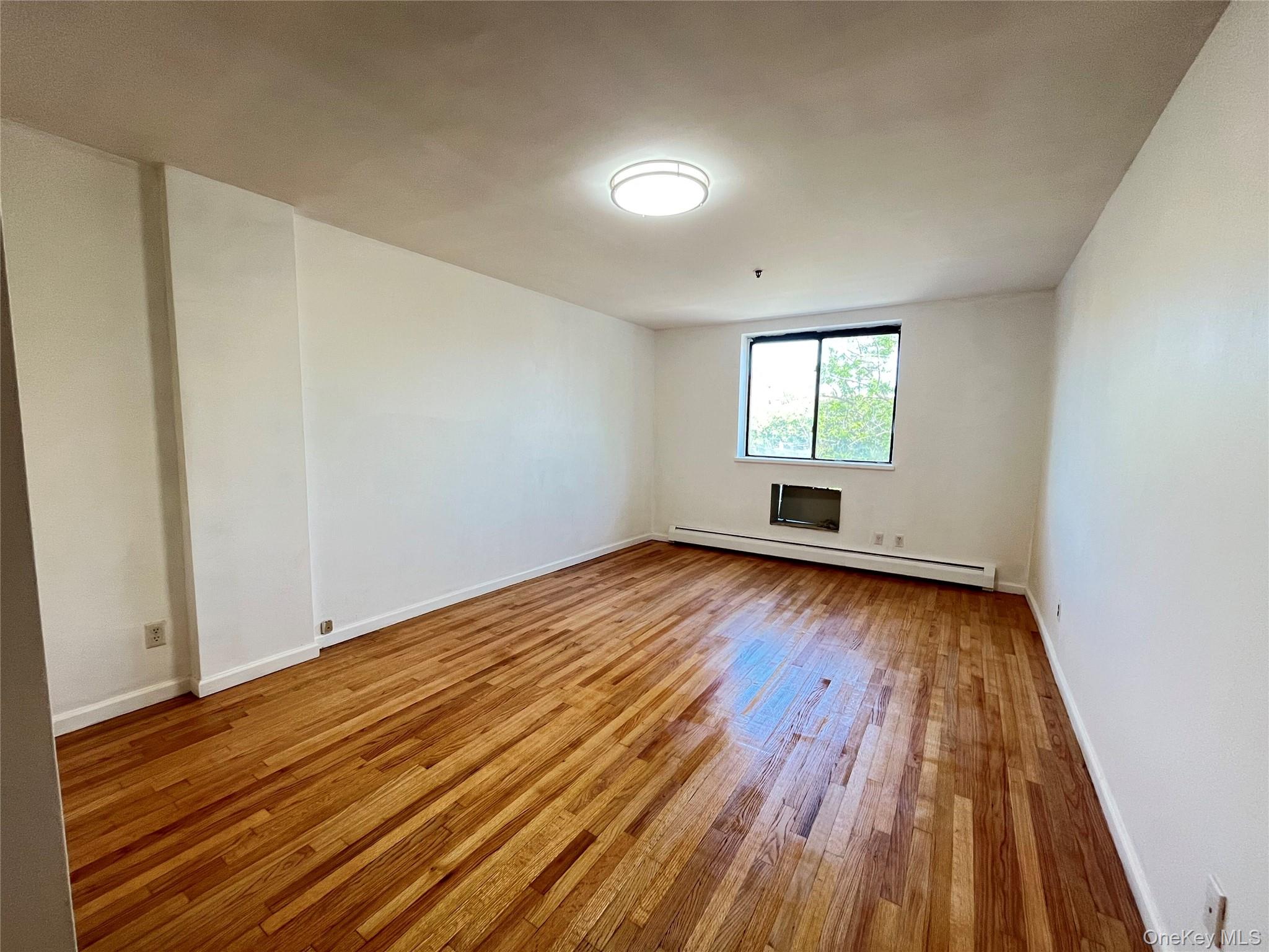 133-38 Avery Avenue, Unit 3FB Queens, NY 11355 - Photo 4 of 8 wooden floor in an empty room with a window