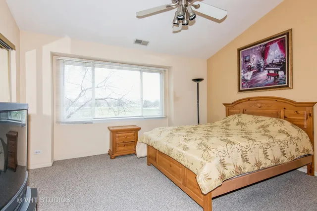 a bed sitting in a spacious bedroom next to a window