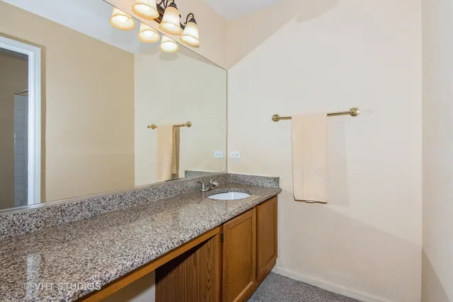 a bathroom with a granite countertop sink and a mirror