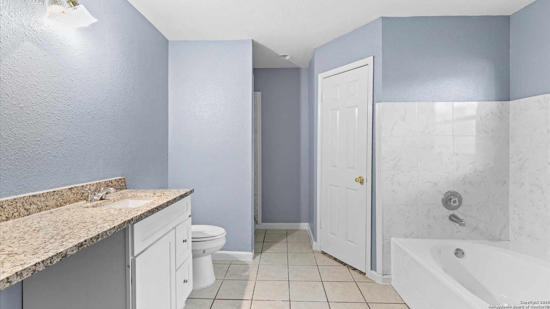 8622 Ridge Flower San Antonio, TX 78239 - Photo 13 of 19 a bathroom with a granite countertop sink a toilet and shower