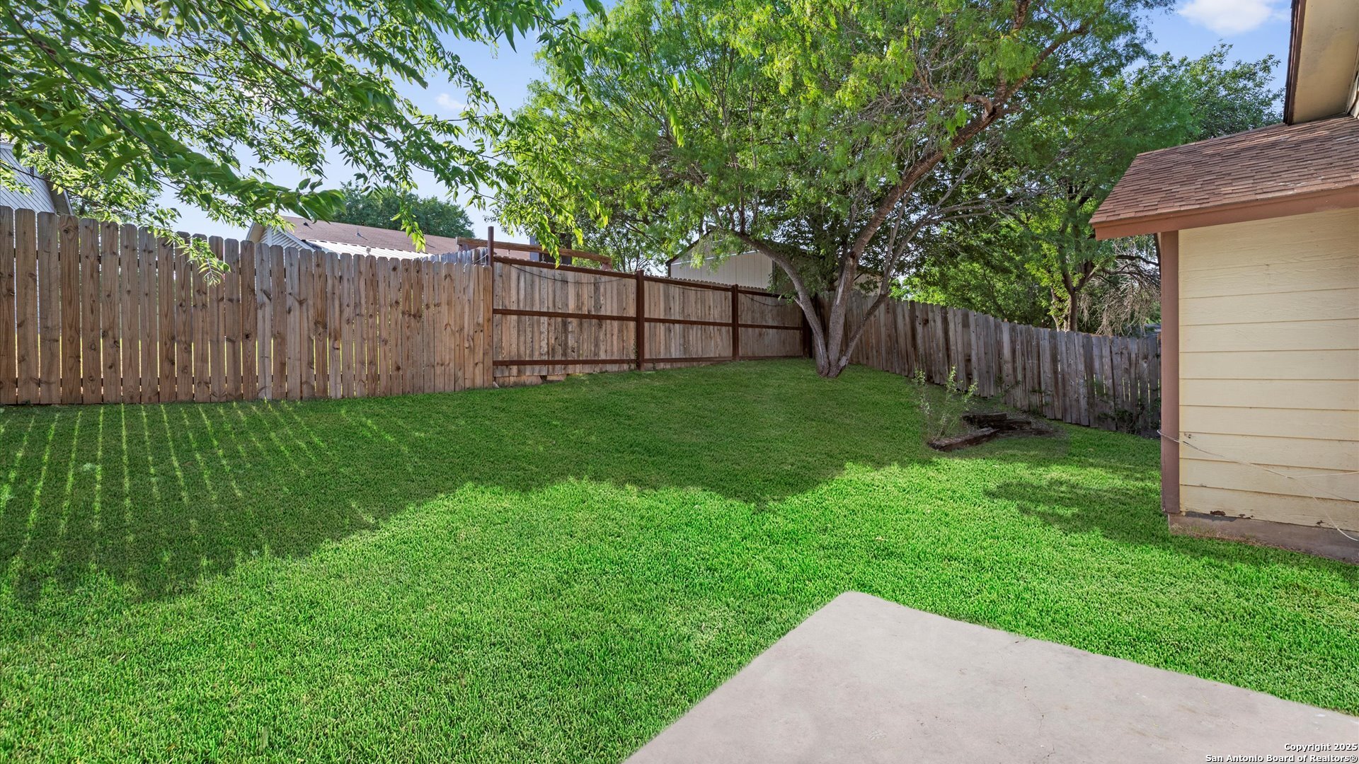 8622 Ridge Flower San Antonio, TX 78239 - Photo 14 of 19 a view of a backyard with large trees and wooden fence