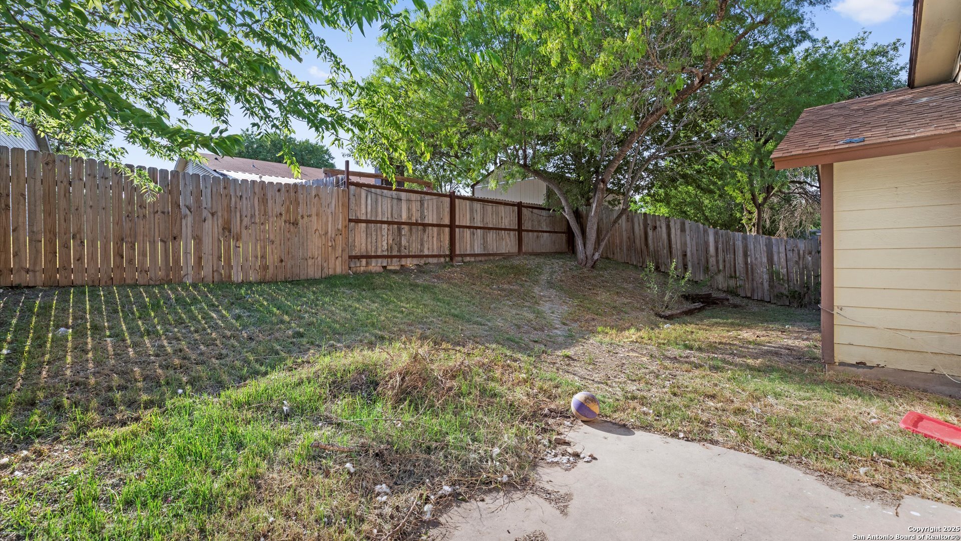 8622 Ridge Flower San Antonio, TX 78239 - Photo 17 of 19 a view of a backyard with large trees and wooden fence