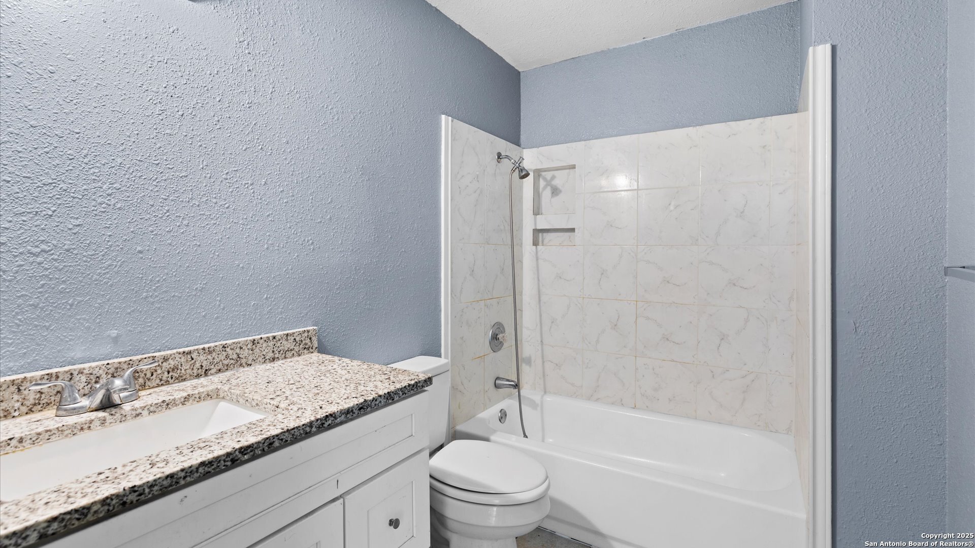 8622 Ridge Flower San Antonio, TX 78239 - Photo 10 of 19 a bathroom with a granite countertop sink a toilet and shower