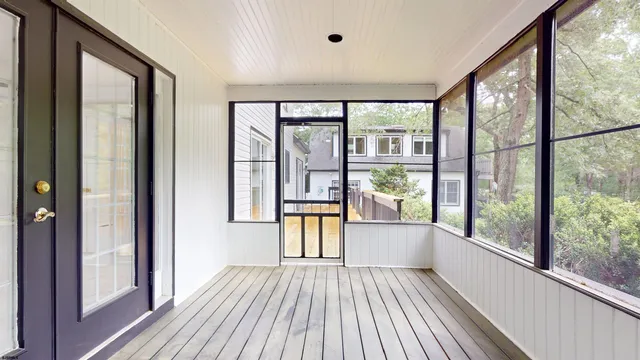 an empty room with wooden floor & windows
