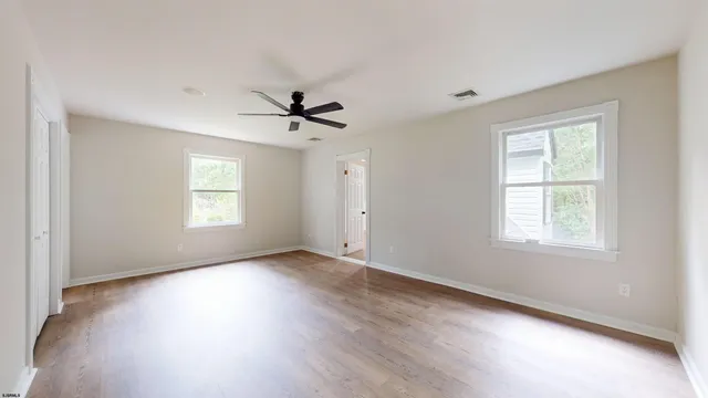 a view of a hallway with wooden floor and windows