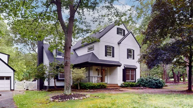 a front view of a house with yard and green space