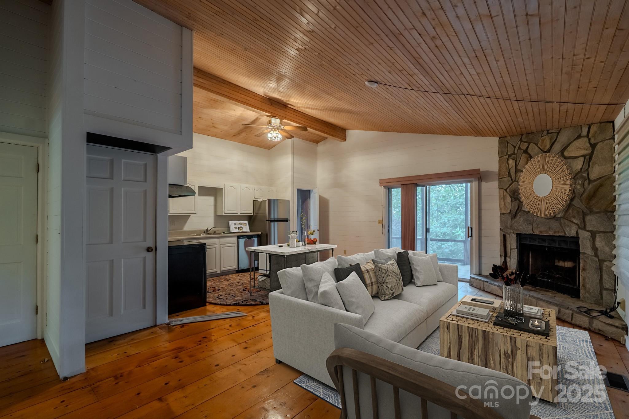 130 Piney Rdg Lane Saluda, NC 28773 - Photo 41 of 48 a living room with furniture a fireplace and a dining table with wooden floor