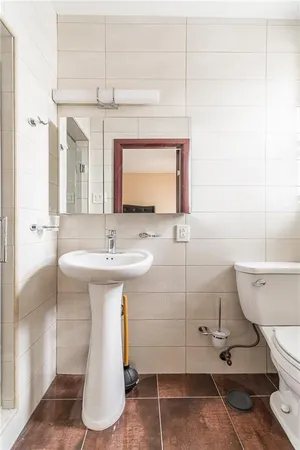 a bathroom with a sink a toilet and shower