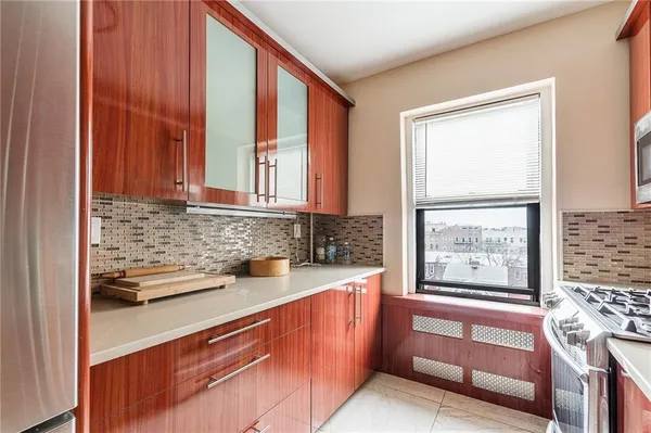a kitchen with stainless steel appliances wooden cabinets and a window