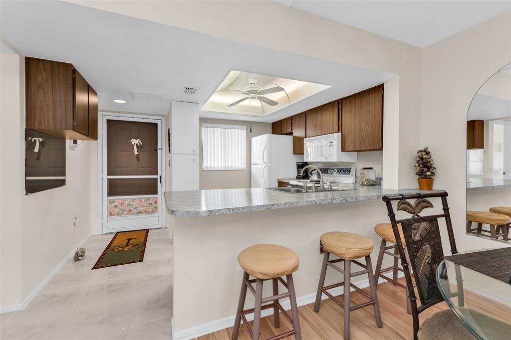 25225 Rampart Boulevard, Unit 1604 Punta Gorda, FL 33983 - Photo 10 of 41 a kitchen with stainless steel appliances granite countertop a stove a sink and a refrigerator with wooden floor