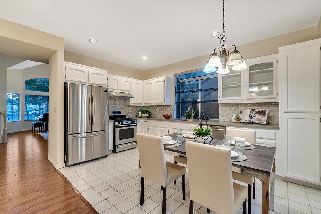 239 Balboa Drive Milpitas, CA 95035 - Photo 20 of 57 a kitchen with stainless steel appliances granite countertop a refrigerator a stove a sink dishwasher a kitchen island with a dining table and chairs
