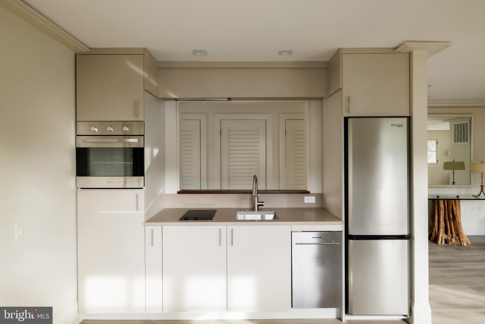 2740 Chain Bridge Road Northwest Washington, DC 20016 - Photo 41 of 50 a kitchen with a refrigerator a microwave a sink and cabinets