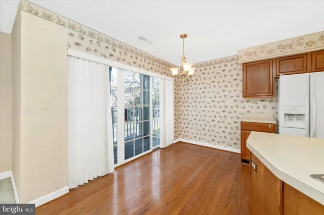 a view of a kitchen with a fridge and wooden floor