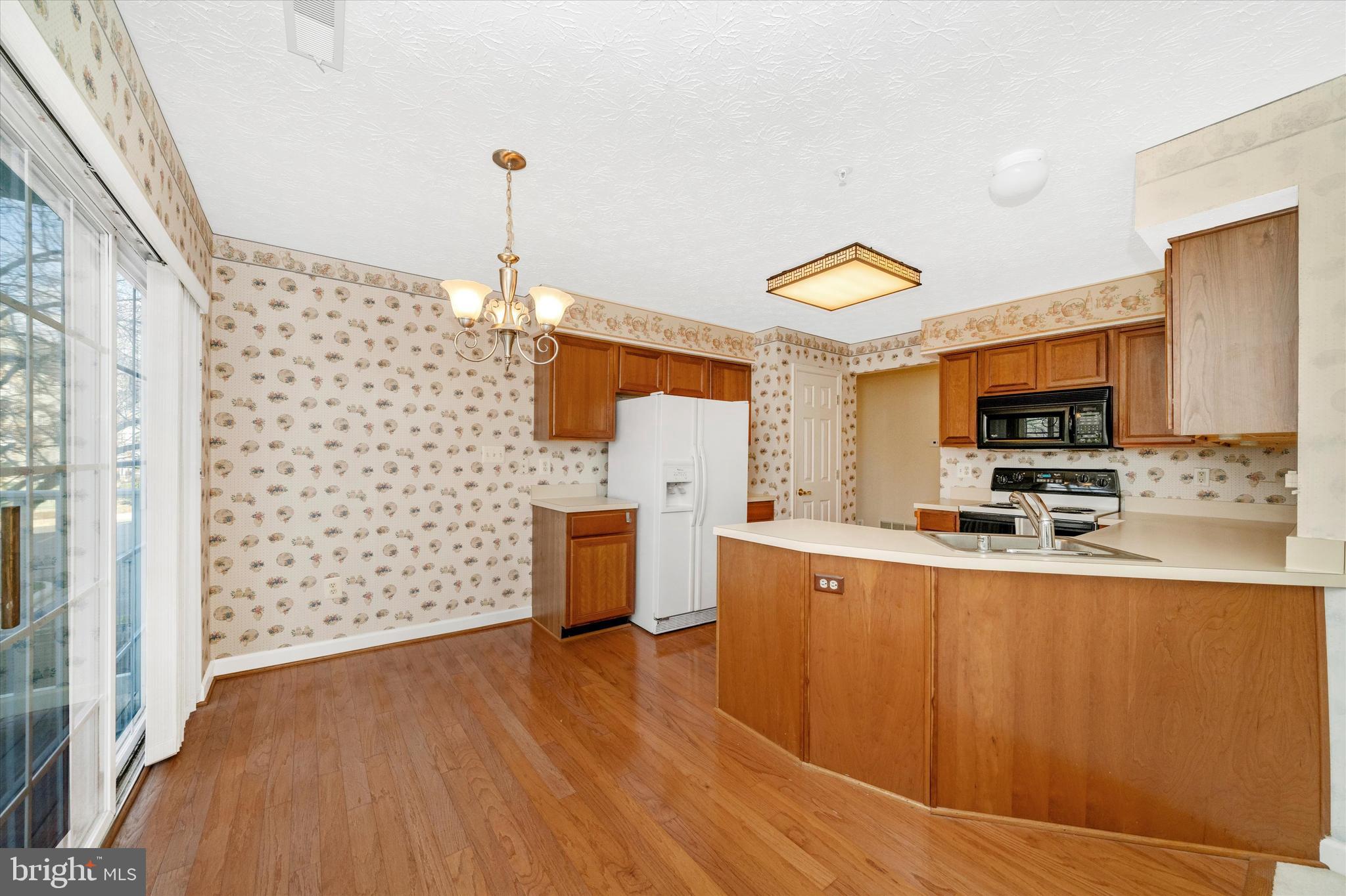 6117 Springwater Place, Unit 1723 Frederick, MD 21701 - Photo 19 of 50 a kitchen with stainless steel appliances a stove a sink a microwave a refrigerator and cabinets
