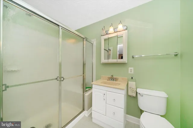 a bathroom with a toilet sink vanity and mirror