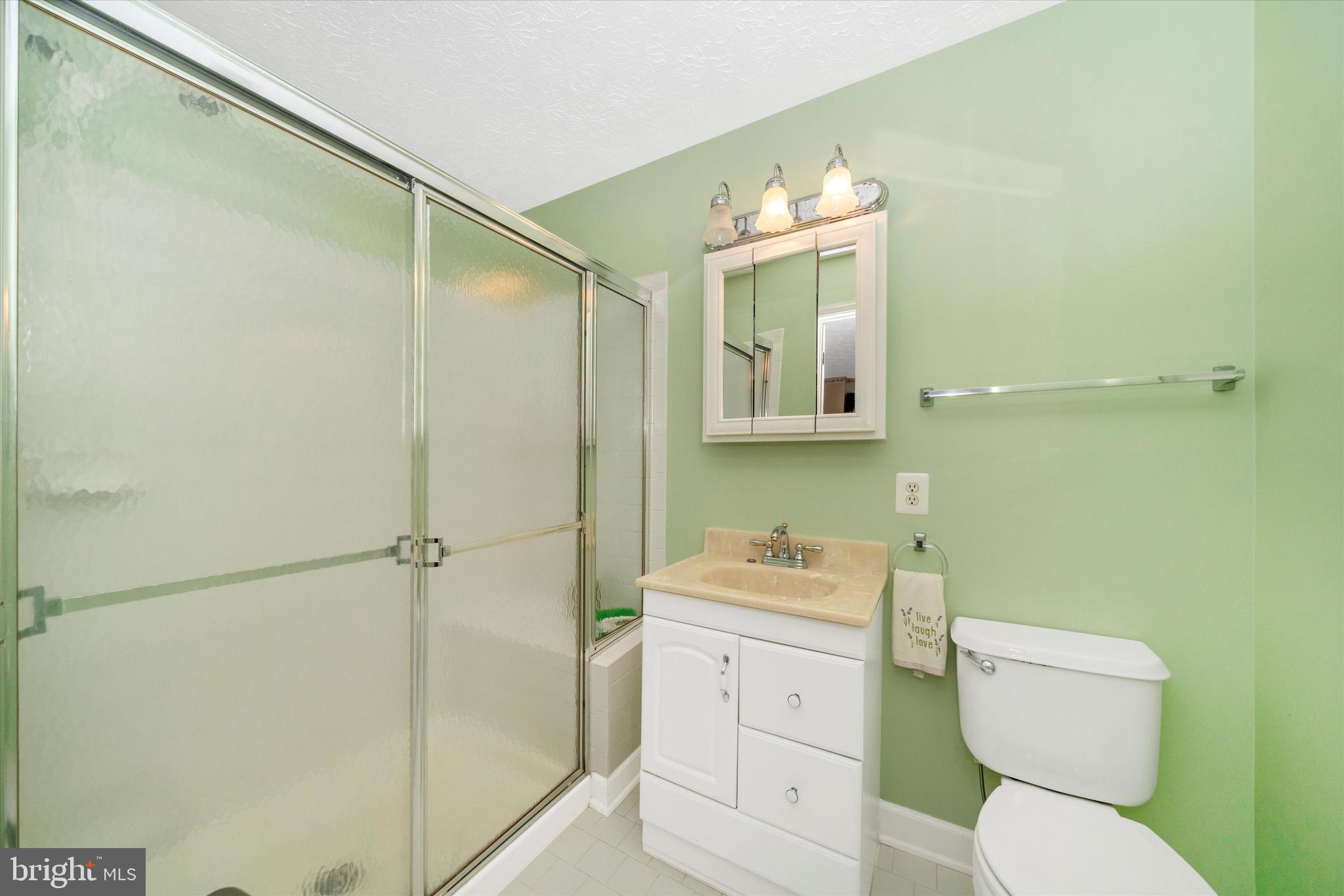 6117 Springwater Place, Unit 1723 Frederick, MD 21701 - Photo 30 of 50 a bathroom with a toilet sink vanity and mirror