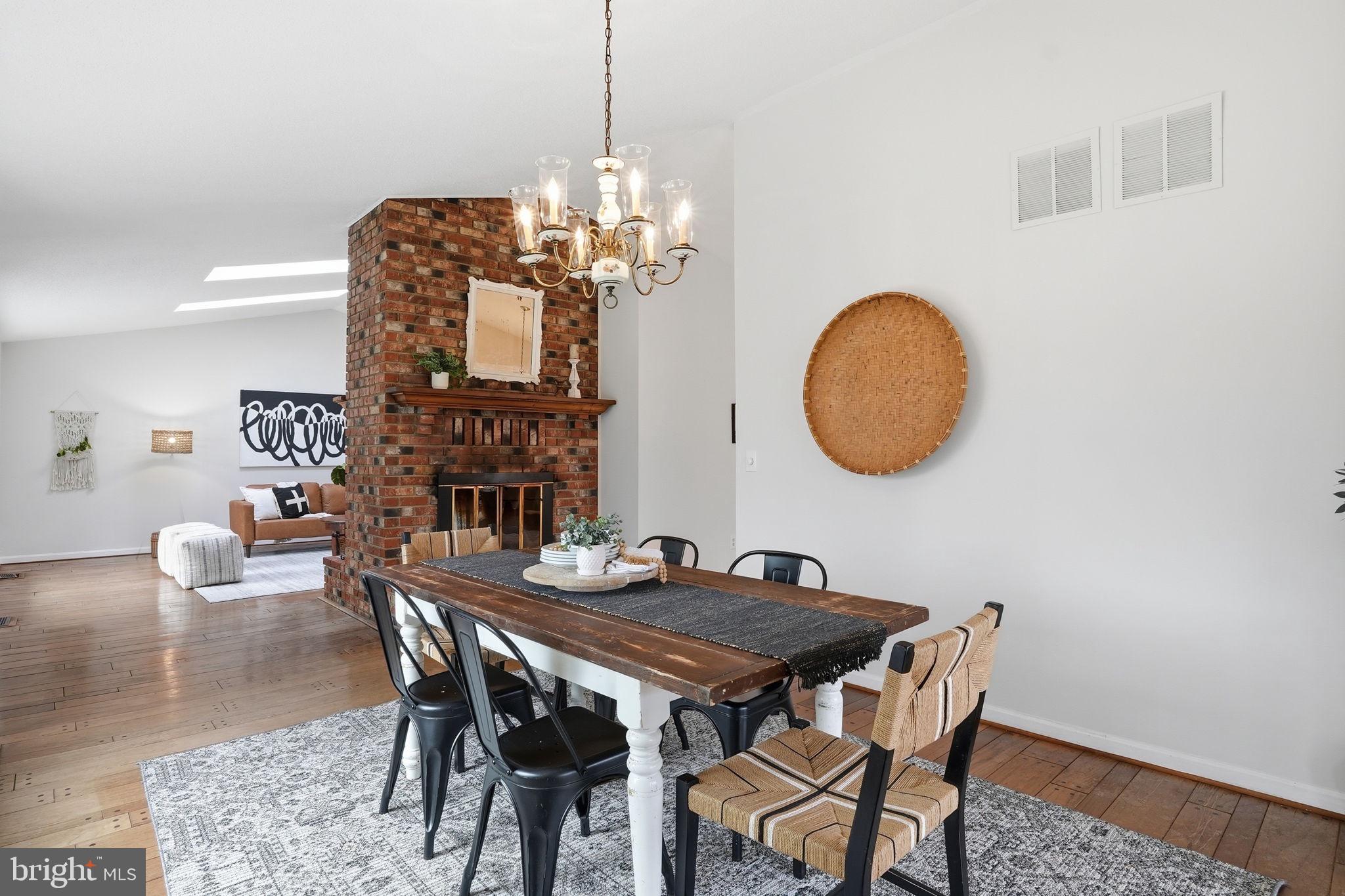18311 Queen Anne Bridge Road Bowie, MD 20716 - Photo 16 of 46 a view of a dining room with furniture a chandelier and wooden floor