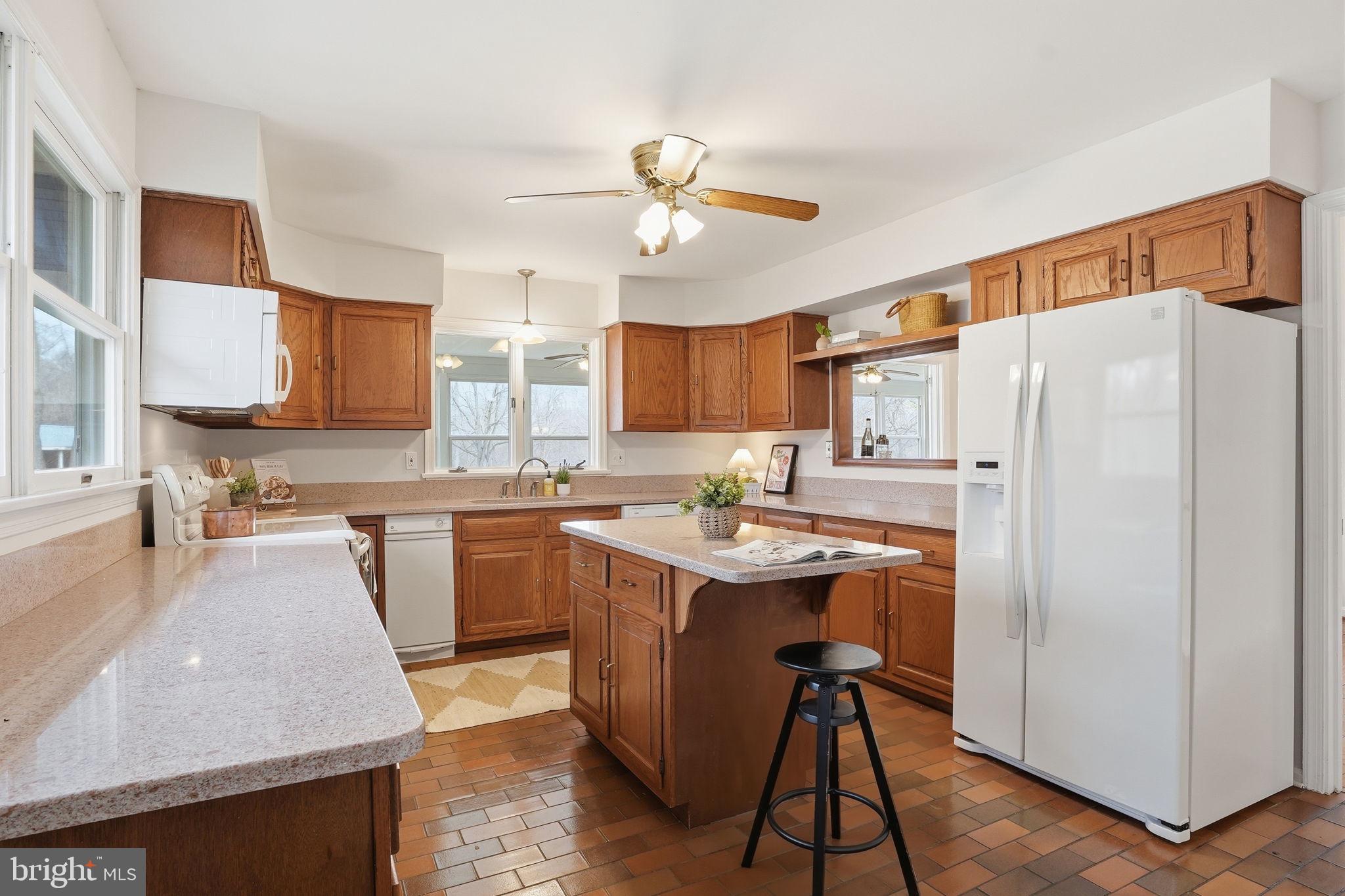 18311 Queen Anne Bridge Road Bowie, MD 20716 - Photo 18 of 46 a kitchen with a sink a refrigerator and wooden cabinets
