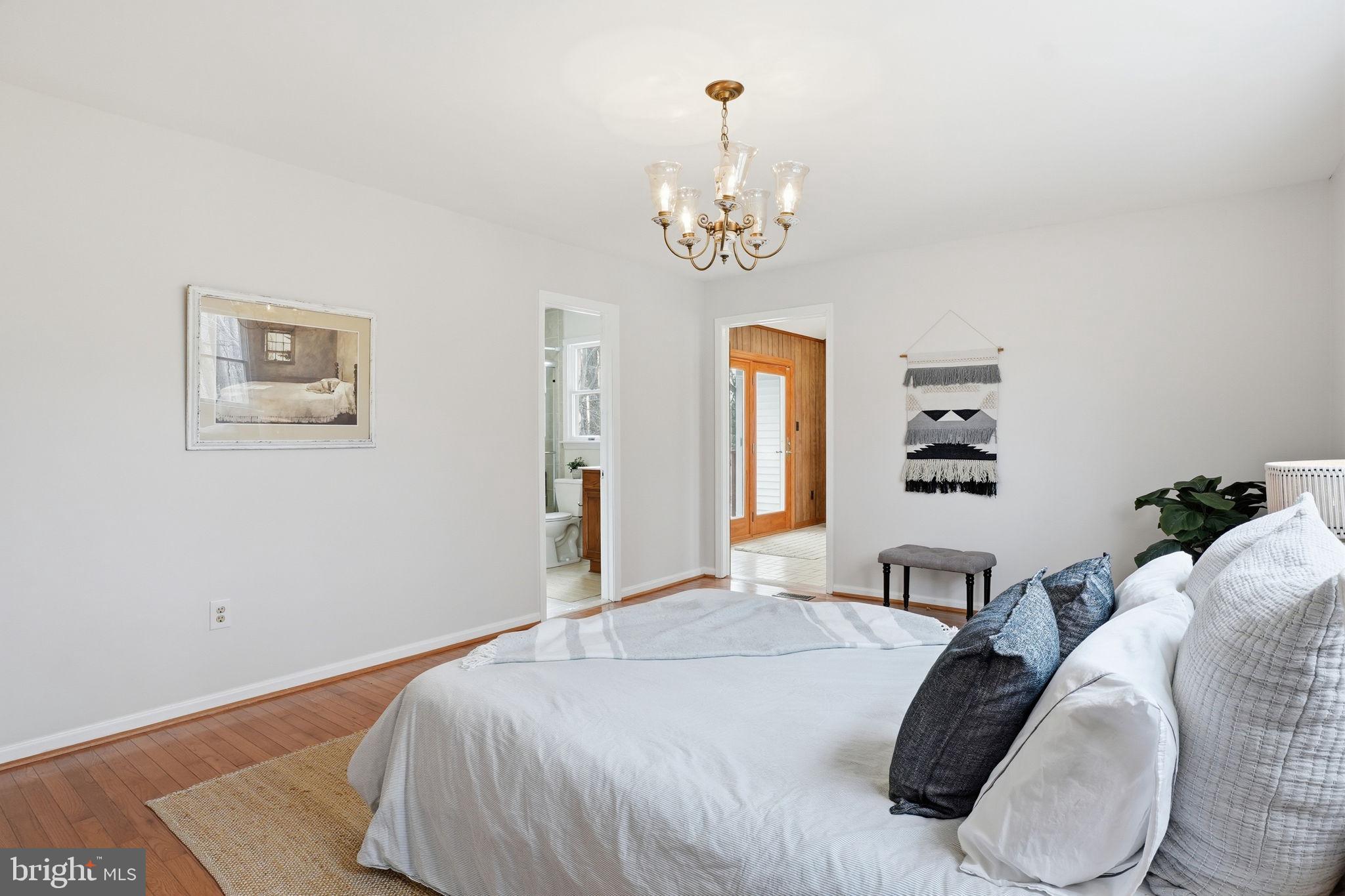 18311 Queen Anne Bridge Road Bowie, MD 20716 - Photo 30 of 46 a bedroom with a bed and a chandelier