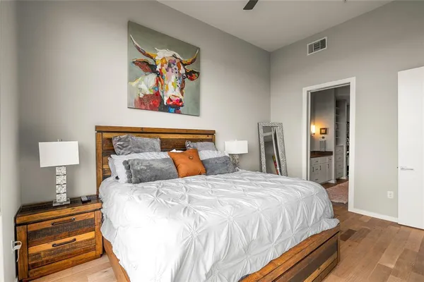 a bedroom with bed and wall painting with wooden floor