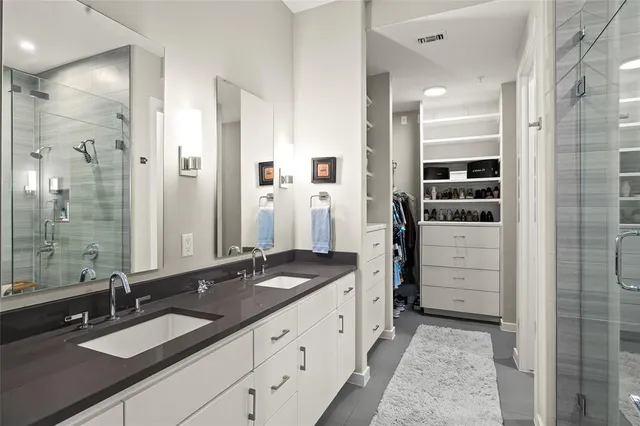 a bathroom with a granite countertop sink a mirror and a shower