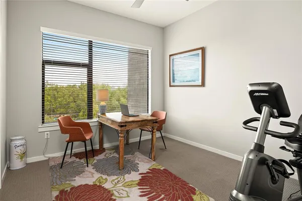 a view of a workspace with furniture and a window
