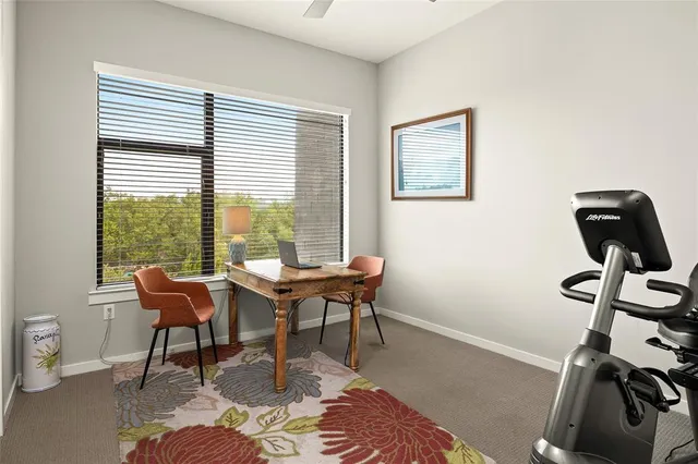 a view of a workspace with furniture and a window