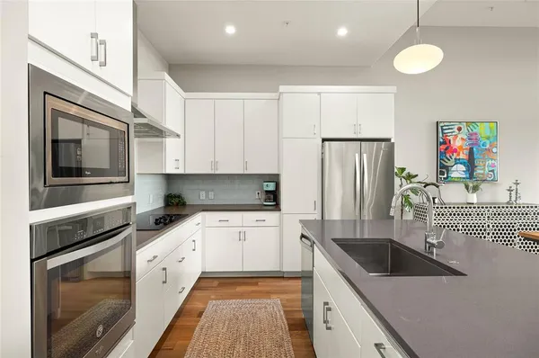 a kitchen with granite countertop a sink stove and refrigerator