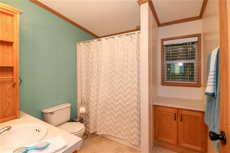 120 Goldscheitter Road Sarver, PA 16055 - Photo 14 of 20 THE HALLWAY FULL BATH FEATURES TWO VANITY CABINETS FOR STORAGE, A TUB SURROUND, AND ADDITIONAL COUNTER SPACE