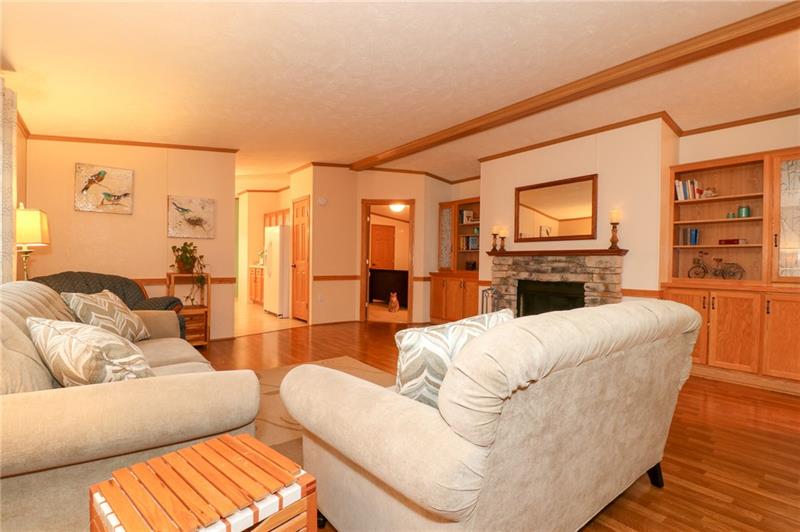 120 Goldscheitter Road Sarver, PA 16055 - Photo 3 of 20 THE LIVING ROOM WITH VAULTED CEILING, WARM HARDWOOD FLOORS, LARGE PICTURE WINDOW, AND CHARMING STONE FACED LOG BURNING FIREPLACE.