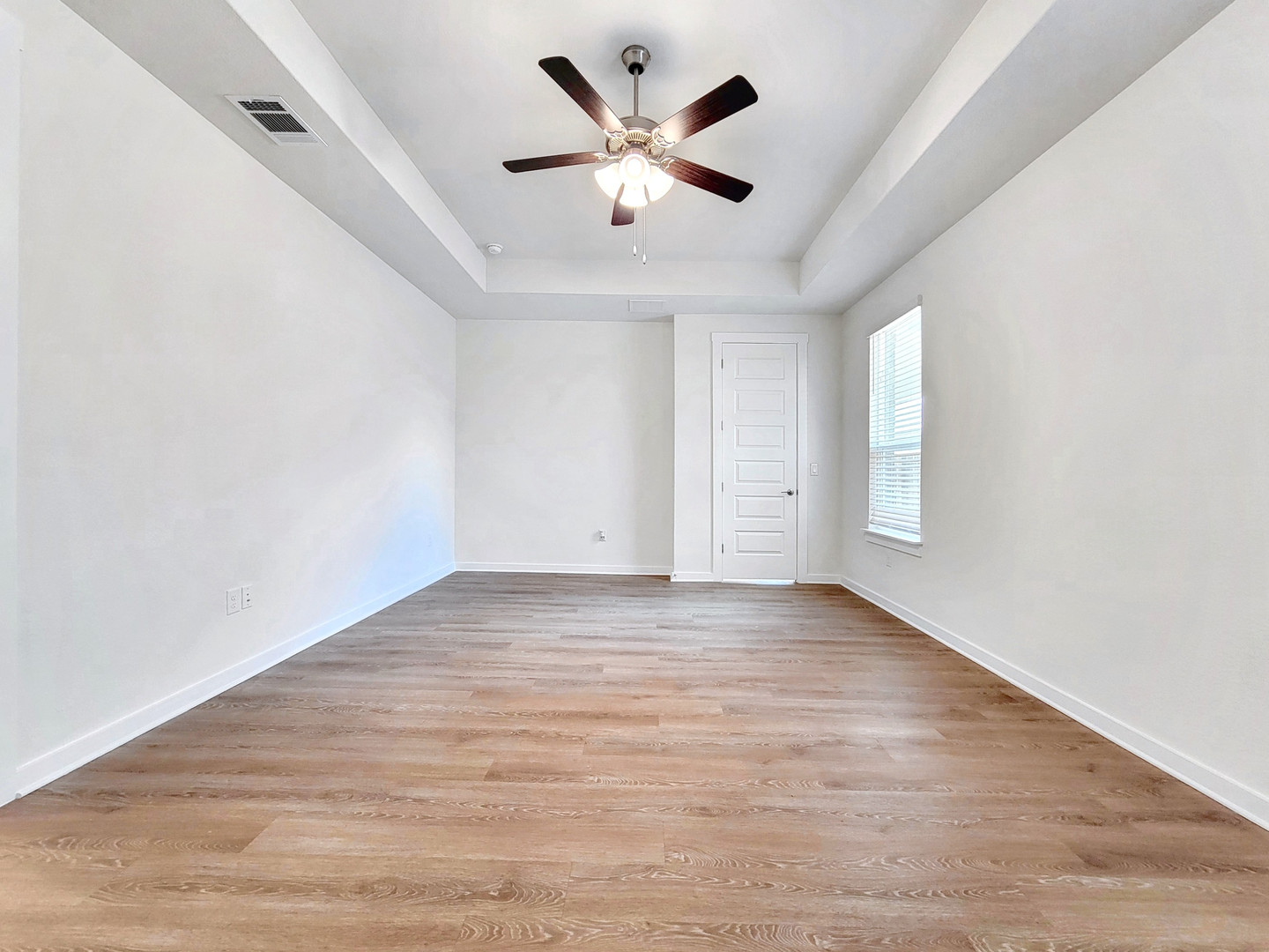 2329 Gabriels Horn Road Leander, TX 78641 - Photo 10 of 23 A spacious room features a tray ceiling with a fan and durable plank flooring.
