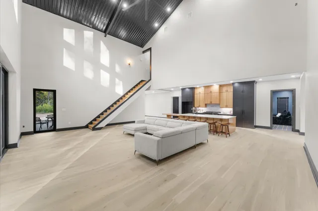 a kitchen with stainless steel appliances kitchen island granite countertop a table chairs sink and cabinets