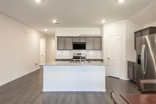 a kitchen with stainless steel appliances a microwave a stove a sink and a refrigerator